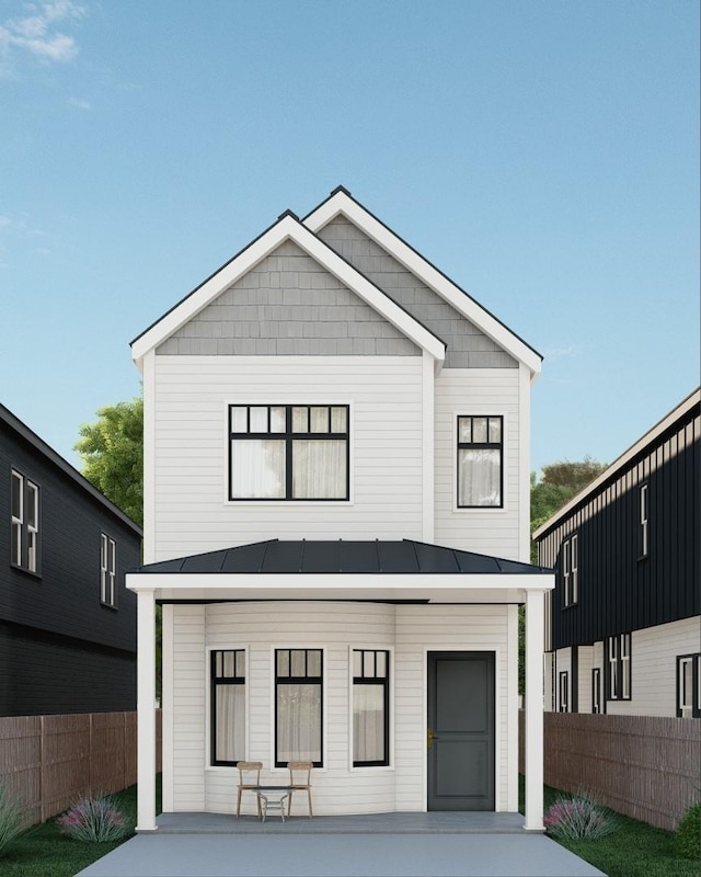 view of front of home featuring metal roof, a standing seam roof, and fence