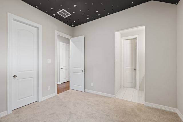 unfurnished bedroom with light colored carpet