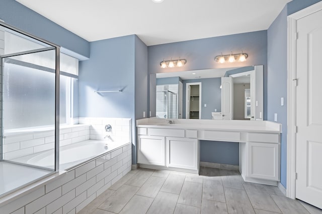 bathroom featuring vanity and independent shower and bath