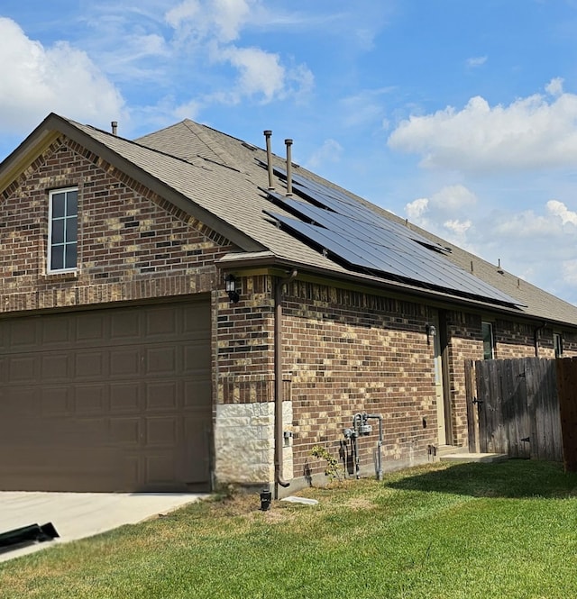 view of home's exterior with a lawn, solar panels, and a garage