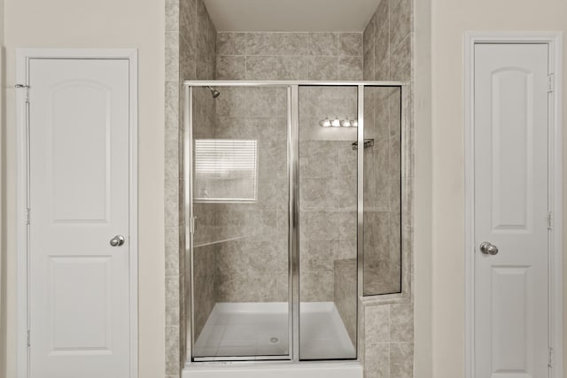 bathroom featuring a shower with door