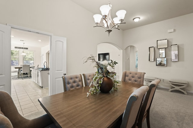 carpeted dining area featuring sink and a chandelier