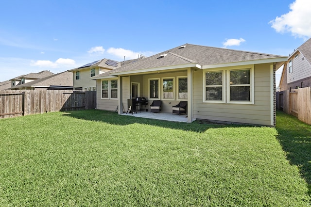 rear view of property with a yard and a patio area