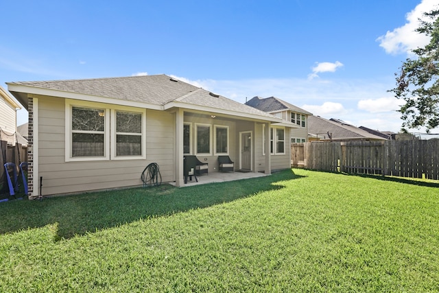 back of house with a lawn and a patio