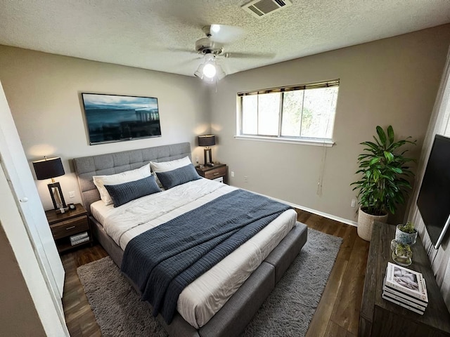 bedroom featuring ceiling fan, dark wood-type flooring, and a textured ceiling