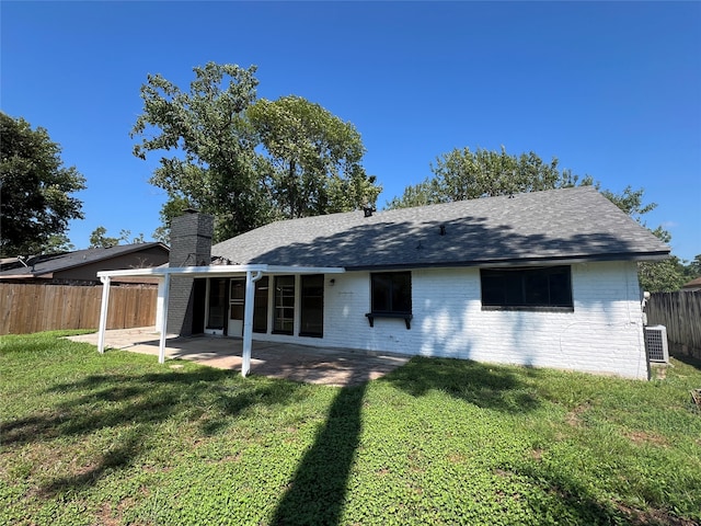 back of property with central AC, a patio area, and a lawn