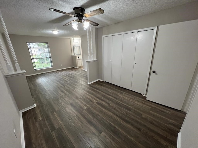 unfurnished bedroom featuring a textured ceiling, dark hardwood / wood-style flooring, a closet, and ceiling fan