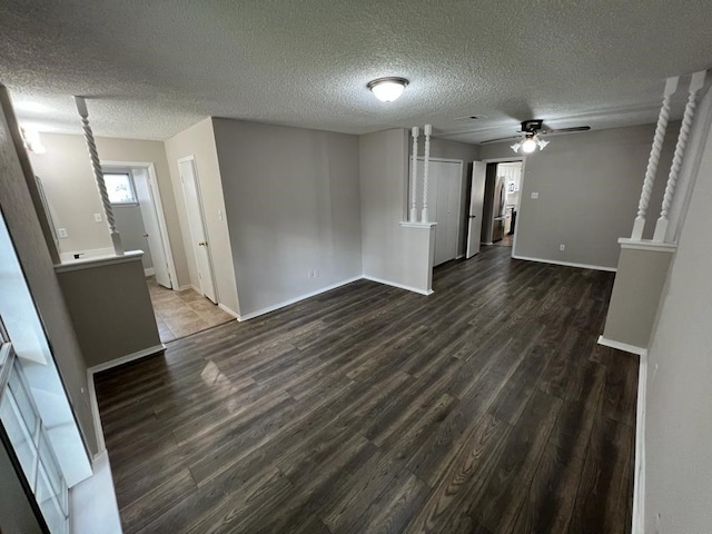 unfurnished living room with a textured ceiling, dark hardwood / wood-style flooring, and ceiling fan