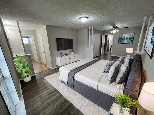 bedroom featuring ceiling fan, dark hardwood / wood-style flooring, and a textured ceiling