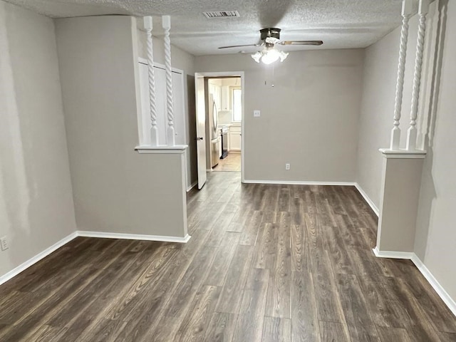 spare room with ceiling fan, dark wood-type flooring, and a textured ceiling