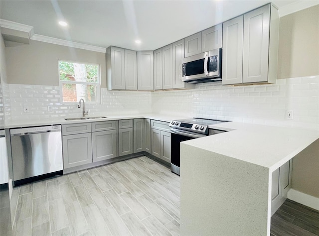 2222 Peppermill Rd, Houston, TX 77080 - kitchen with appliances with stainless steel finishes, a sink, gray cabinets, ornamental molding, and light countertops