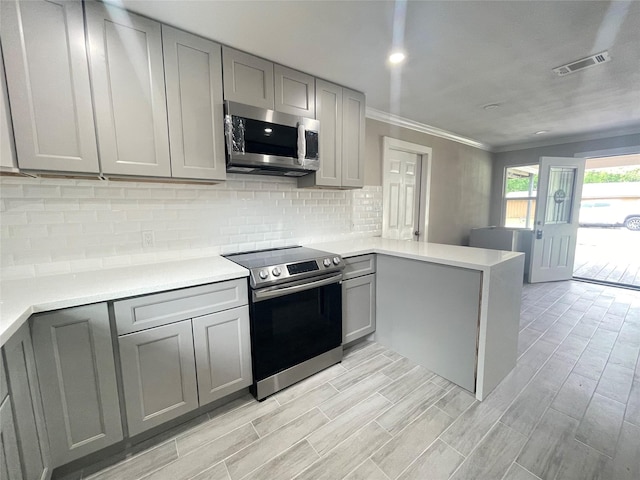 kitchen with gray cabinets, kitchen peninsula, and appliances with stainless steel finishes