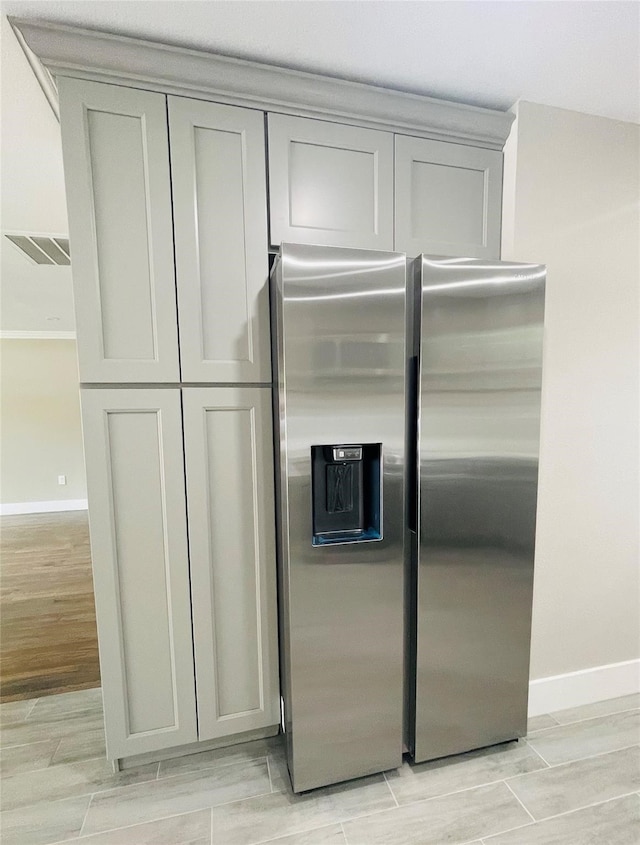 kitchen featuring gray cabinets, light wood-type flooring, and stainless steel fridge with ice dispenser