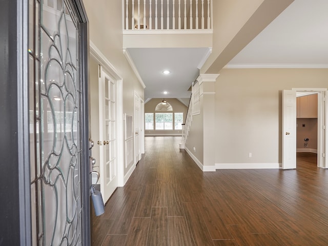 foyer featuring dark hardwood / wood-style floors, ornate columns, and crown molding