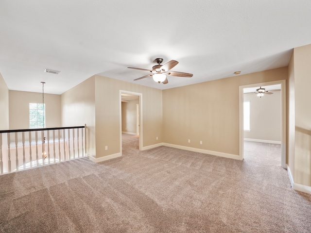 spare room featuring light colored carpet and ceiling fan