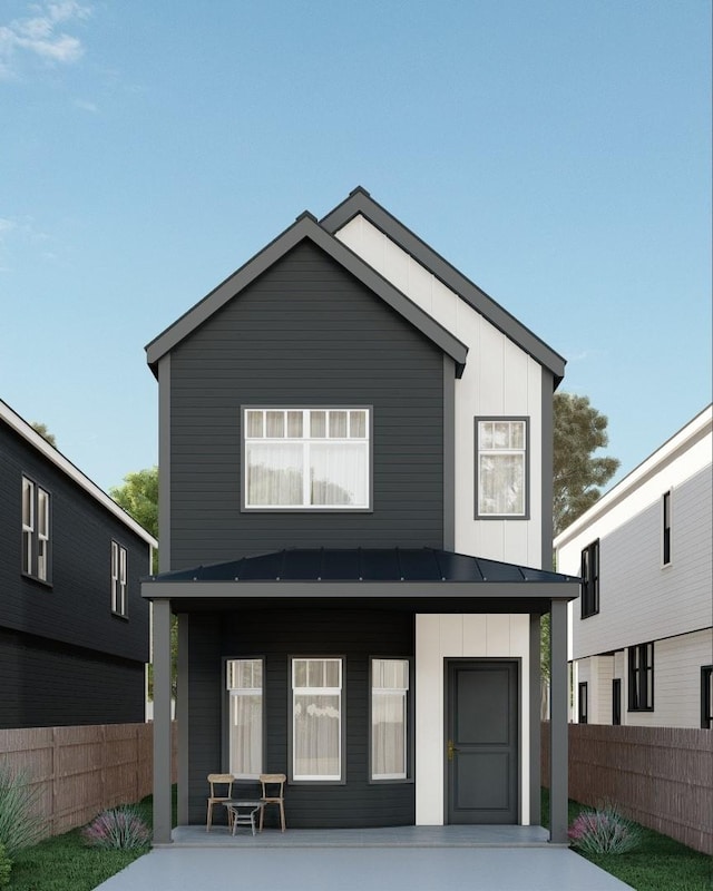 view of front facade with a standing seam roof, fence, metal roof, and board and batten siding