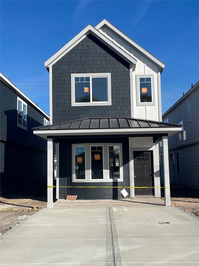 modern inspired farmhouse with a porch, a standing seam roof, and metal roof