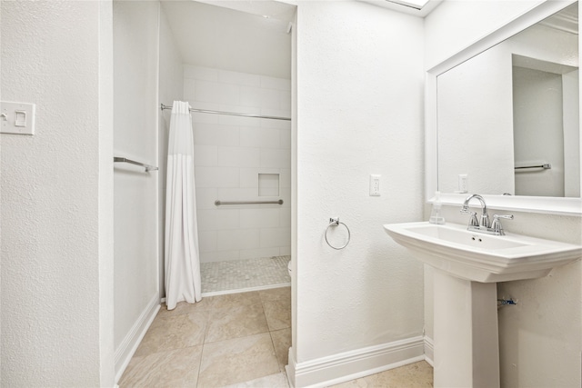 bathroom with a shower with shower curtain and tile patterned flooring