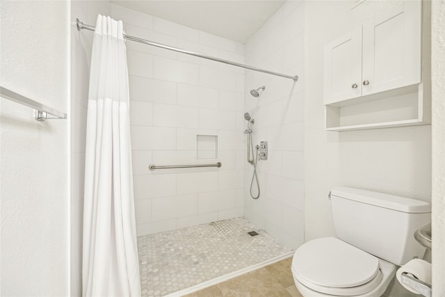 bathroom with tile patterned floors, toilet, and walk in shower