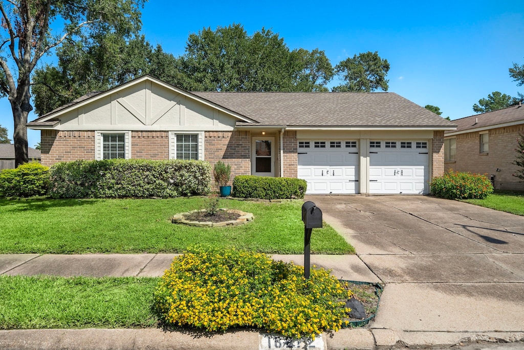 ranch-style house with a front yard and a garage