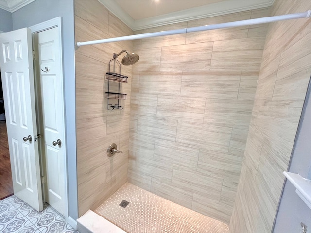 bathroom with ornamental molding and tiled shower