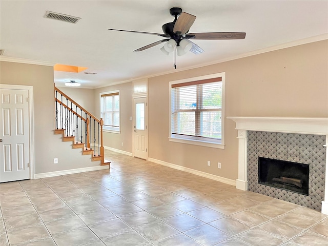 unfurnished living room with crown molding, ceiling fan, a fireplace, and a healthy amount of sunlight