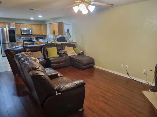 living room with ceiling fan and dark hardwood / wood-style flooring