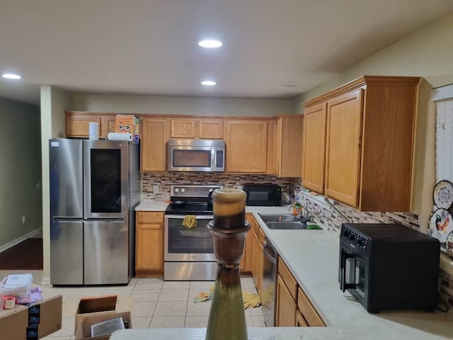 kitchen with decorative backsplash, light tile patterned floors, stainless steel appliances, and sink