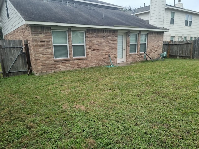 back of house with a lawn