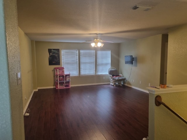 unfurnished living room with dark hardwood / wood-style flooring and ceiling fan