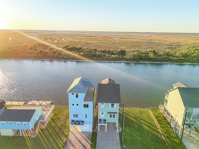 aerial view at dusk featuring a water view