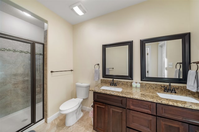 bathroom with tile patterned floors, vanity, a shower with shower door, and toilet