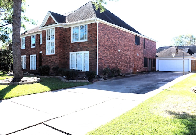 view of front of house featuring a front yard, a garage, and an outdoor structure