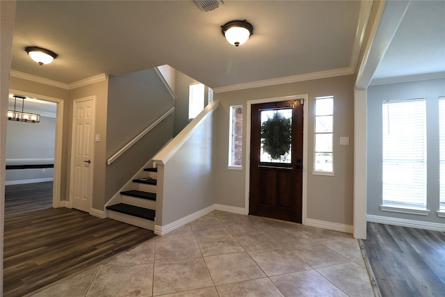 foyer with hardwood / wood-style floors, a chandelier, and ornamental molding