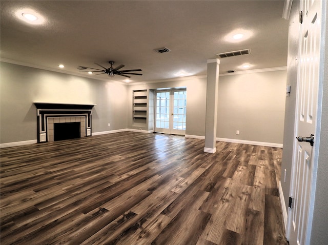 unfurnished living room featuring french doors, ceiling fan, crown molding, a fireplace, and dark hardwood / wood-style floors