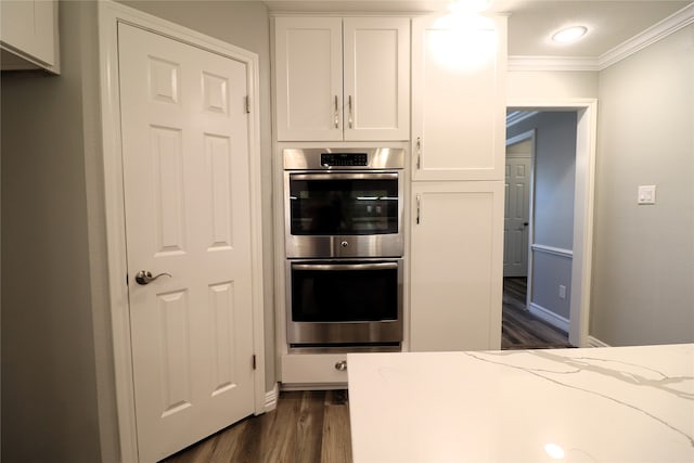 kitchen with dark hardwood / wood-style flooring, white cabinetry, double oven, and light stone counters