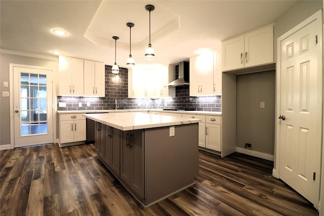 2304 Eagles Way, Pearland, TX 77581 - kitchen featuring wall chimney range hood, white cabinetry, a center island, decorative backsplash, and ornamental molding