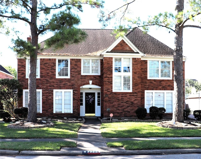 2304 Eagles Way, Pearland, TX 77581 - view of front of house with brick siding, a front lawn, and a shingled roof