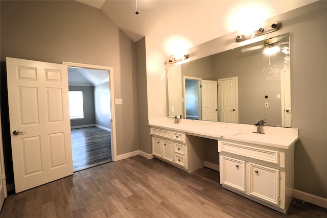 bathroom with vanity, vaulted ceiling, and hardwood / wood-style flooring