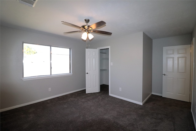 unfurnished bedroom featuring a closet, dark carpet, and ceiling fan