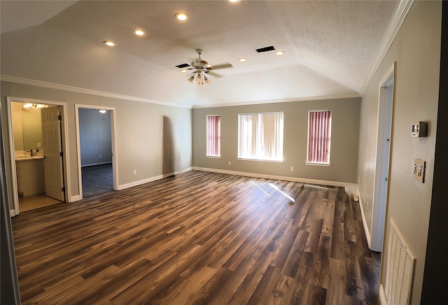 interior space with connected bathroom, dark wood-type flooring, lofted ceiling, and ornamental molding