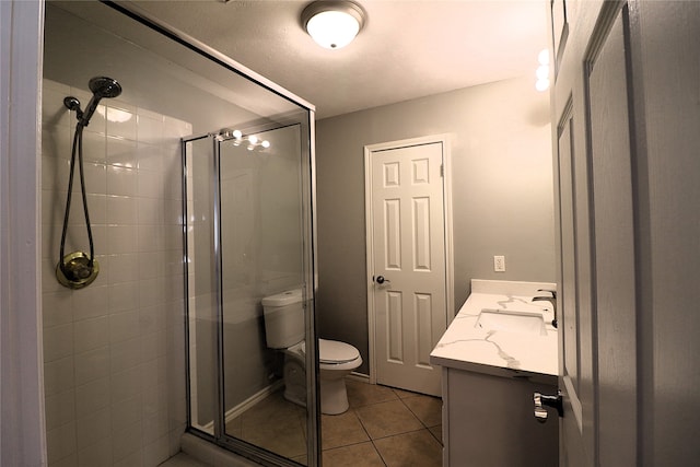 bathroom with tile patterned floors, vanity, toilet, and an enclosed shower