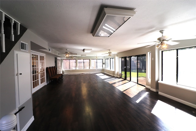 unfurnished room with french doors, plenty of natural light, a textured ceiling, and hardwood / wood-style flooring