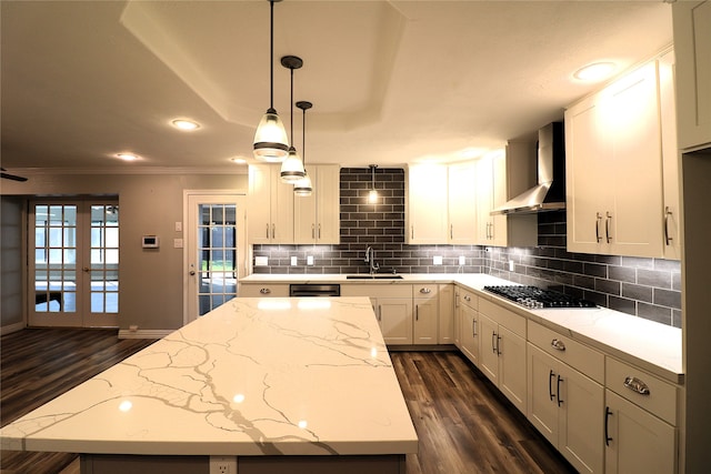 kitchen featuring french doors, wall chimney exhaust hood, stainless steel appliances, decorative light fixtures, and dark hardwood / wood-style floors