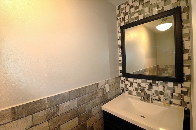 bathroom featuring vanity and tile walls