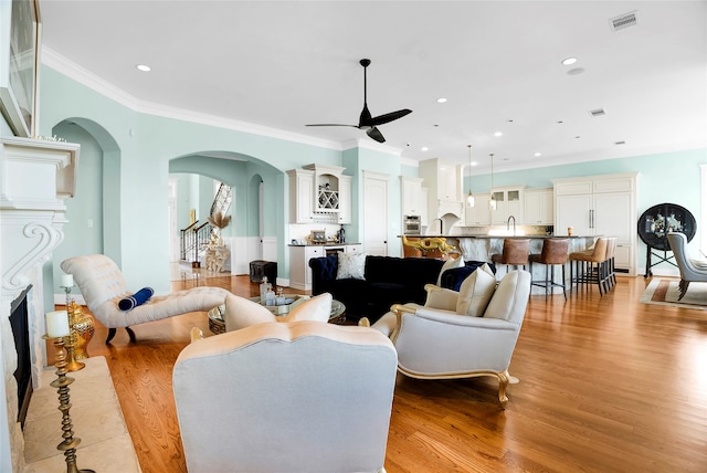 living room featuring a fireplace, light hardwood / wood-style floors, and ornamental molding