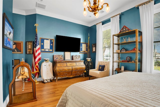 bedroom with multiple windows, crown molding, light hardwood / wood-style flooring, and an inviting chandelier