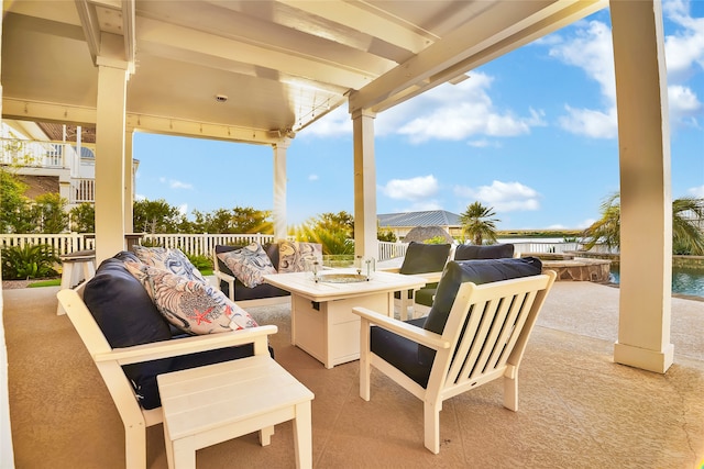 view of patio featuring a water view and an outdoor living space with a fire pit