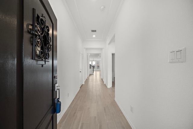 hall featuring light wood-type flooring and crown molding