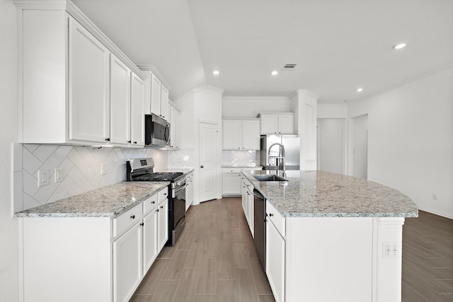 kitchen featuring a center island with sink, white cabinets, and appliances with stainless steel finishes